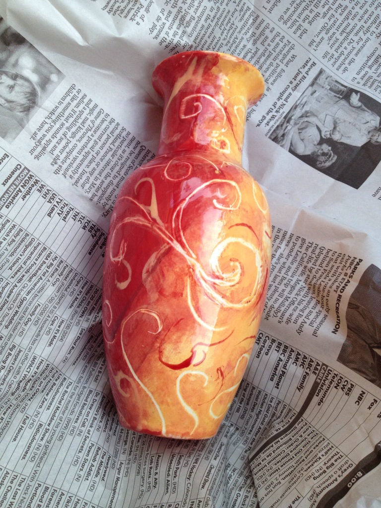 hand painted vase in orange and red with swirls